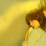 Lu Yuxiao en una escena dramática de dorama con luz cinematográfica cálida y un compañero de reparto detrás.
